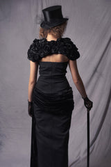 black off-shoulder gown with black velvet cape and cylinder hat