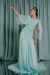 A truly astonishing asymmetric hand-beaded blouse with gracious flowy waterfall sleeves in softest silk chiffon. The bodice is hand pleated. The pleats are arranged in a manner to resemble the flowing nature of the cristaline water, embellished with crystal pearls and custom made pearl fringes.