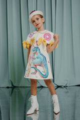 Luxury clothing for girls Playful hand-painted short denim cape with a silk lining and gorgeous hand-painted donuts with beaded, colourful rainbow jimmies on an off-white background. Sunny yellow bows