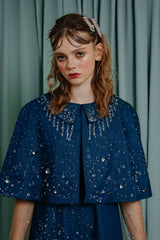 Short soft and breathable denim cape with intricate crystal and transparent resin pearl detailing creates a beautiful and eye-catching pattern that shimmers in the light.