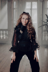 Artistic take on the classic polka dot pattern in a belted sheer blouse with a rounded sunburst neckline and bishop sleeves