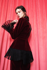 Deep crimson velvet fitted jacket with silk shawl lapel and pleated organza details.