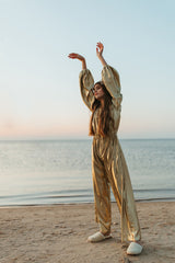 Charming golden silk jumpsuit with a deep V-neck and strings for closure at neckline.