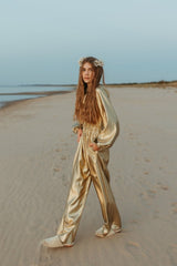 Charming golden silk jumpsuit with a deep V-neck and strings for closure at neckline.