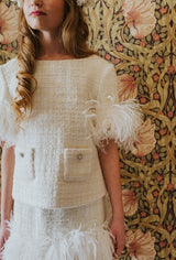 Creamy-white tweed top with 3/4 length sleeves decorated with white swan feathers and fringe.