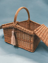 An exquisite wicker picnic basket with a handle and a hinged lid.