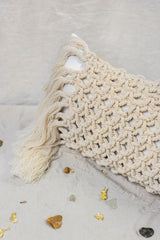 The Riviera Rectangular Cushion is made of linen in ivory white and adorned with a hand-knotted macramé in a natural shade.