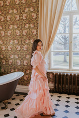 A romantic blush rose ruffle dress with a V-neckline.