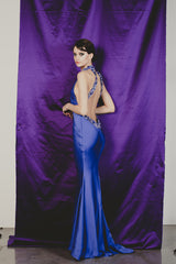 Magnificent purple fitted sheath gown with extreme low cut back.