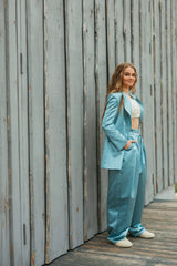 Elegantly tailored summer sky blue glossy silk wide-leg trousers with a high waist and a front button and zipper fastening.