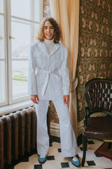 White denim boot-leg trousers with two side pockets, button and zipper in the front.