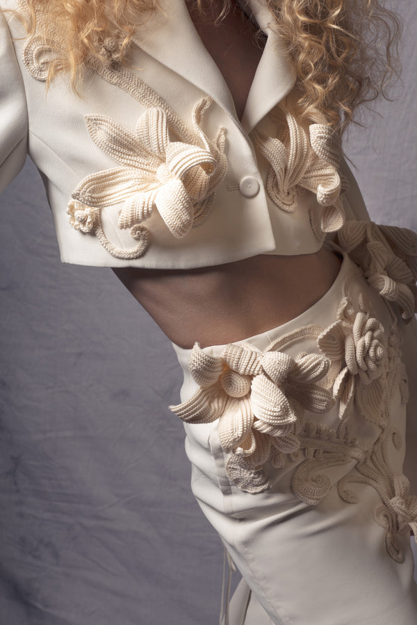 white crop jacket adorned with three-dimensional crochet flowers