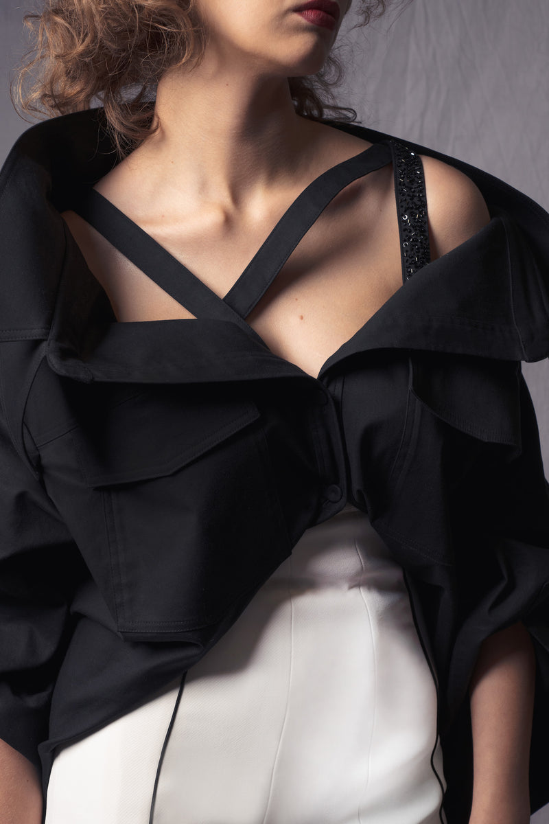 black oversized shirt with asymmetric straps that  slide down exposing the shoulders