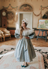 A light blue midi silk dress with bishop sleeves, tulle neckline, and voluminous skirt