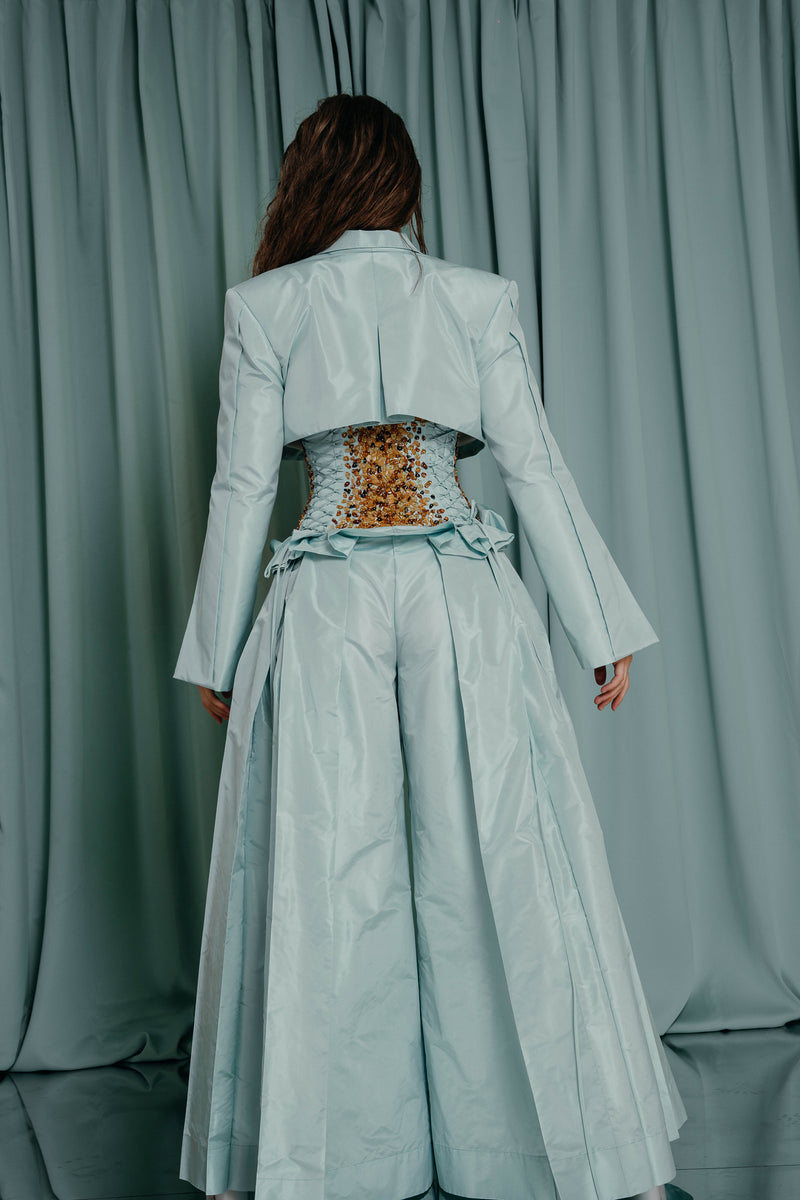 Aquamarine wide-leg trousers, complete with an amber-embroidered bodice 