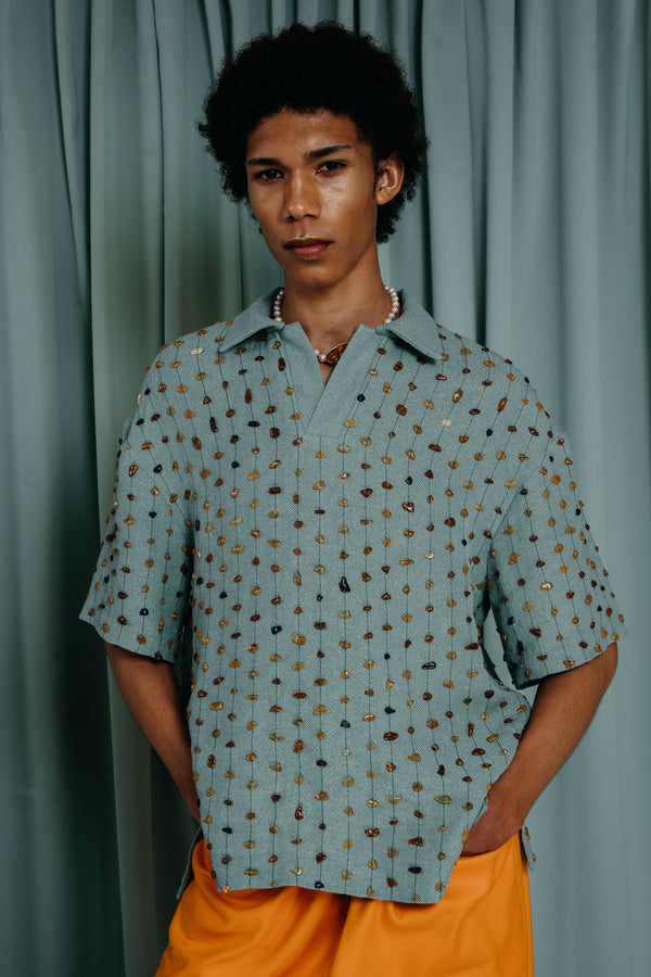 Mesmerising Bermuda tee coloured linen hand woven with a delicate touch of sparkling gold. Fully embroidered with natural amber and gilded beads in symmetrical lines that give an impression of golden honey drops on refreshing sea water. 