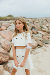 Graceful white denim A-line mini skirt, softly tailored and embellished with decorative pebbles