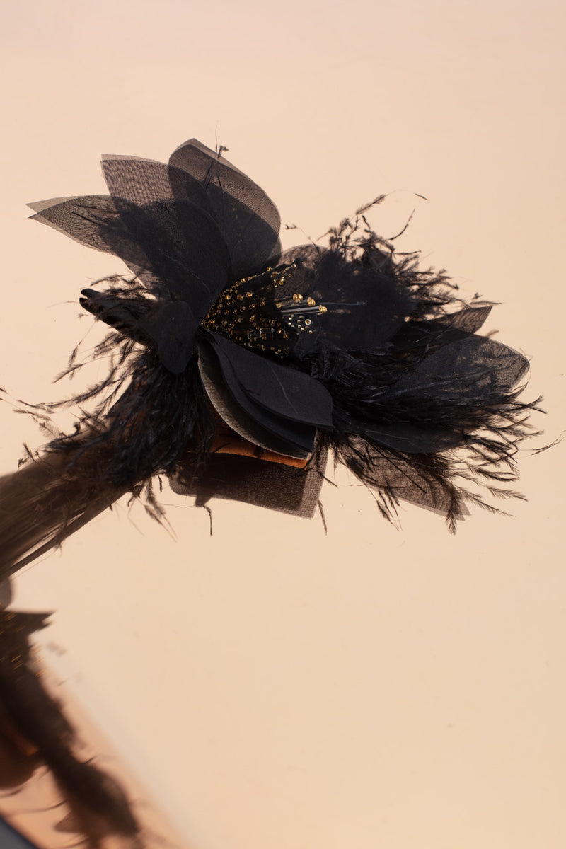 Beautifully crafted black daffodil pin in 100 % silk and gilded bead and ostrich feather trim.