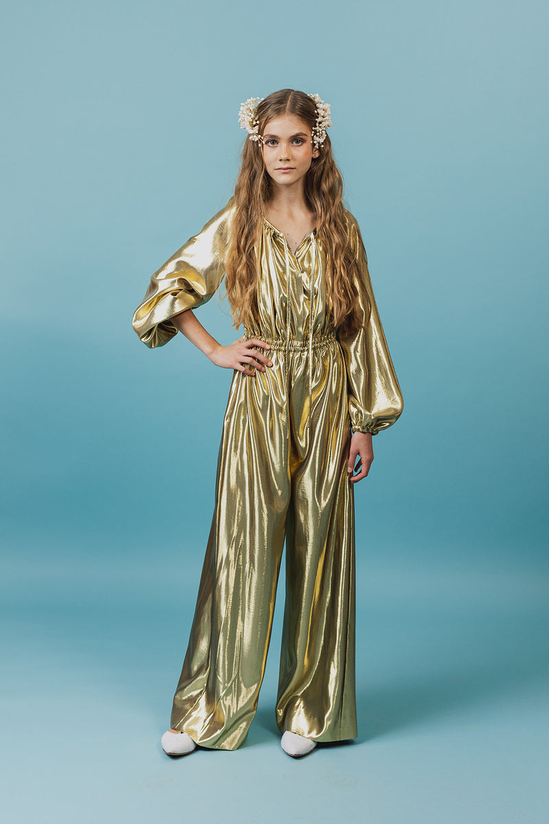 Charming golden silk jumpsuit with a deep V-neck and strings for closure at neckline.