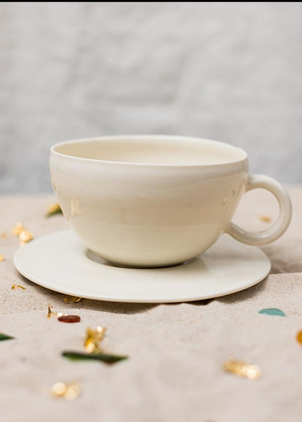 This delicately handcrafted porcelain cup and saucer set is unadorned and beautiful in its modesty.
