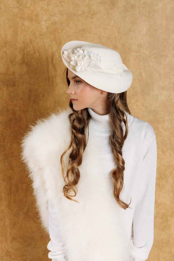 Charming soft white fascinator decorated with delicate white lace, hand-crafted silk flowers and crystals.