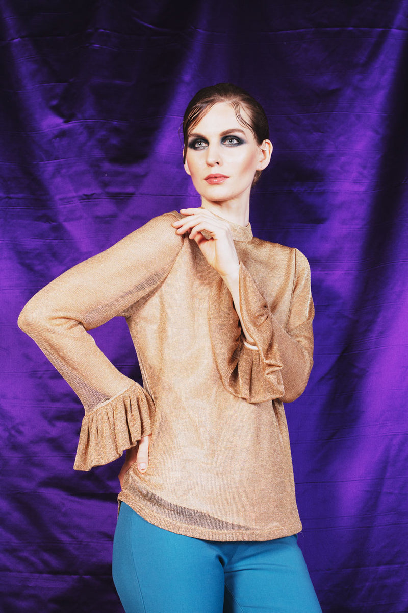 Intricately elegant golden chain knit blouse with poet sleeves and crew collar.