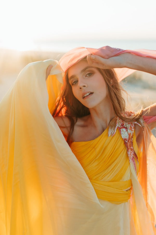 Elegantly soft, sunset-colored one-shoulder empire silk gown.