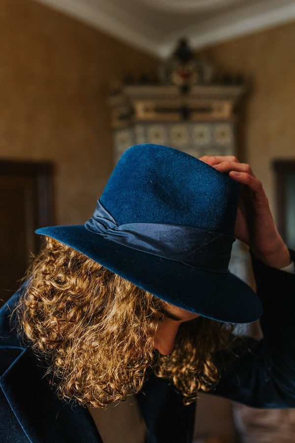 Deep blue elegant fedora hat with wide band.