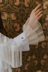 Gracious, soft white asymmetric blouse with inverted pleats from the waist down and a push-button fastening in the front.