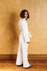 White denim boot-leg trousers with two side pockets, button and zipper in the front.